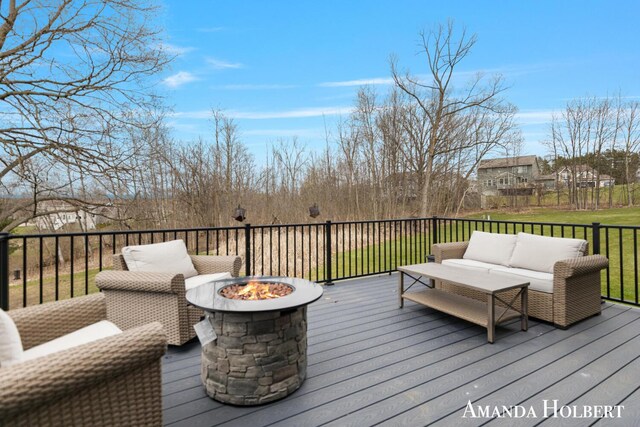 wooden terrace featuring an outdoor living space with a fire pit