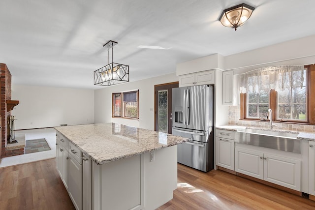 4675 Treat Hwy, Adrian, MI 49221 - kitchen with tasteful backsplash, a center island, stainless steel fridge, a sink, and light wood finished floors