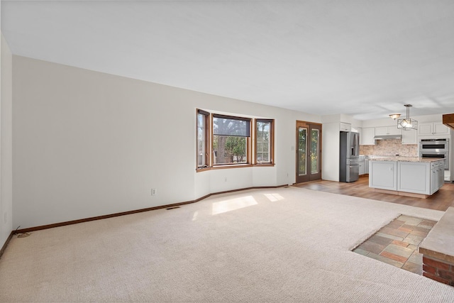 4675 Treat Hwy, Adrian, MI 49221 - unfurnished living room featuring baseboards and light colored carpet