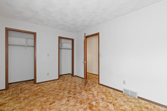 4675 Treat Hwy, Adrian, MI 49221 - unfurnished bedroom with visible vents, baseboards, two closets, and carpet floors