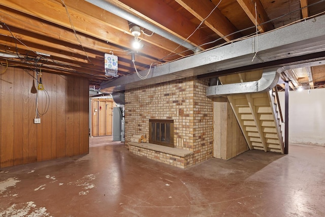 4675 Treat Hwy, Adrian, MI 49221 - unfinished basement featuring wooden walls, a brick fireplace, and stairs