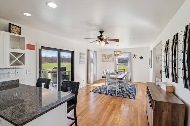 dining room with light wood-type flooring, baseboards, a ceiling fan, and recessed lighting