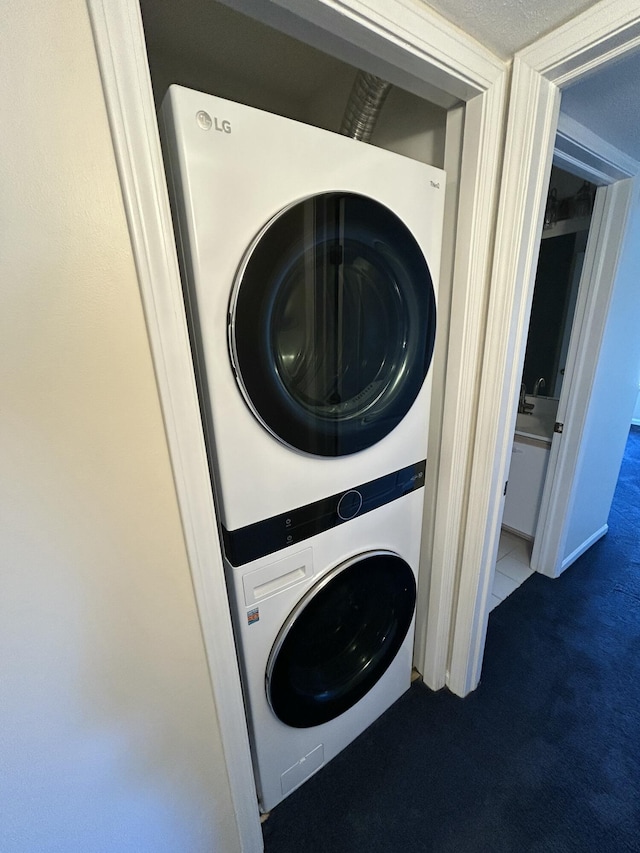 laundry area featuring carpet, stacked washer and dryer, and laundry area