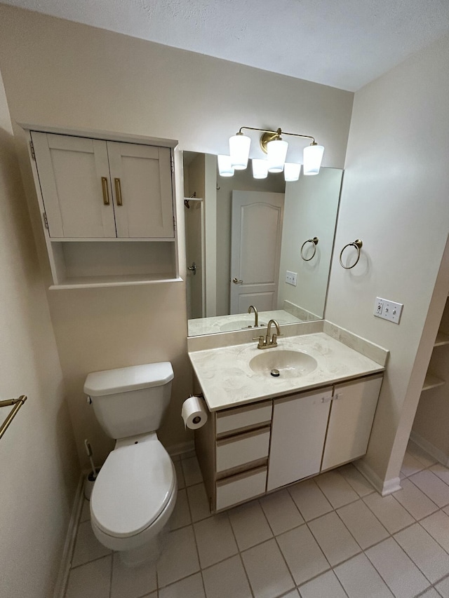 bathroom featuring toilet, tile patterned floors, vanity, and baseboards