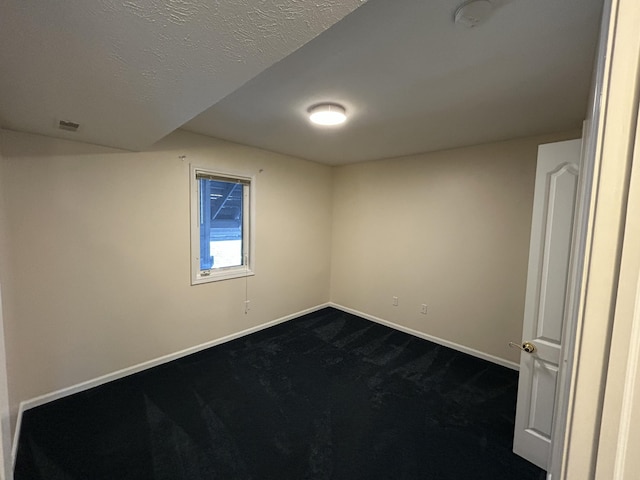 spare room with baseboards and a textured ceiling