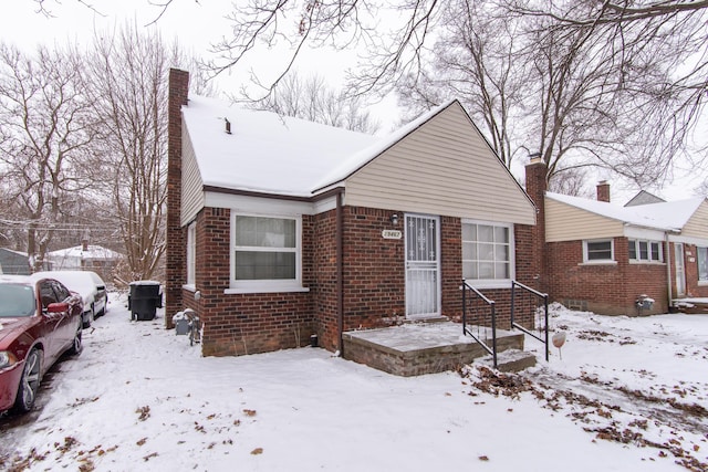 bungalow with brick siding and a chimney