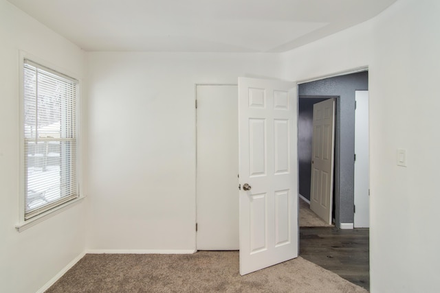 carpeted empty room with baseboards