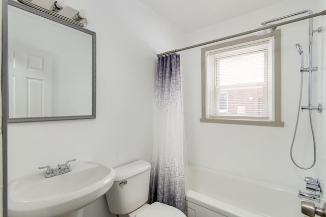 full bathroom with shower / tub combo with curtain, a sink, and toilet