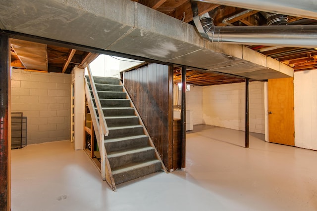 unfinished below grade area featuring stairway and washer / dryer