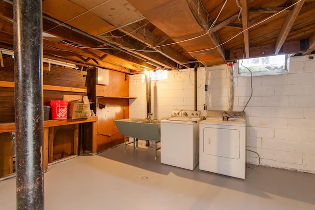 basement featuring washing machine and dryer and a sink