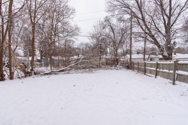 snowy yard featuring fence