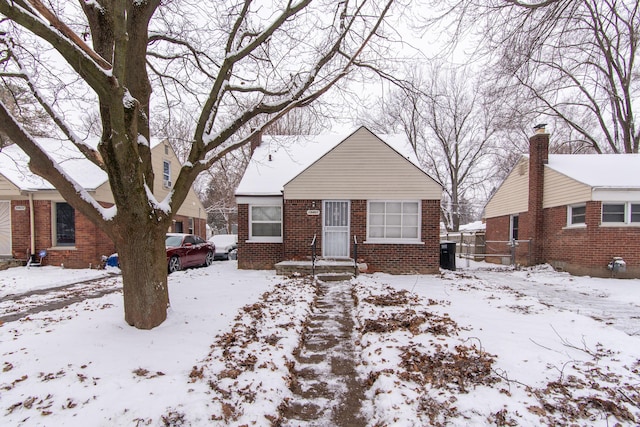 bungalow-style house featuring brick siding and central air condition unit