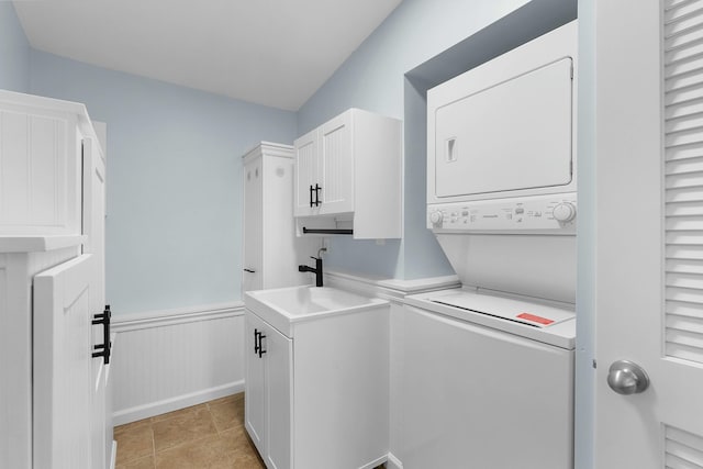 2817 Cumberland Ave, Ann Arbor, MI 48104 - washroom featuring light tile patterned flooring, stacked washer / dryer, wainscoting, cabinet space, and a sink