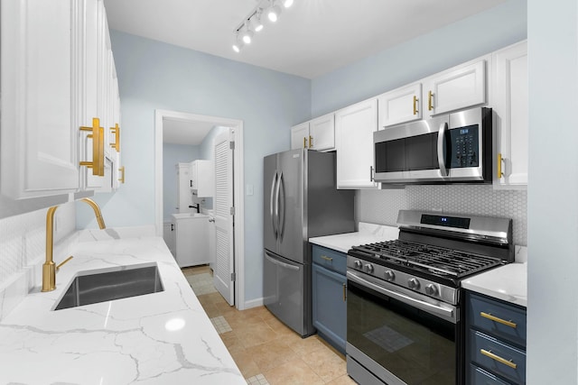 2817 Cumberland Ave, Ann Arbor, MI 48104 - kitchen with light stone countertops, white cabinets, appliances with stainless steel finishes, a sink, and decorative backsplash