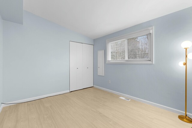 2817 Cumberland Ave, Ann Arbor, MI 48104 - unfurnished bedroom featuring a closet, vaulted ceiling, visible vents, wood finished floors, and baseboards