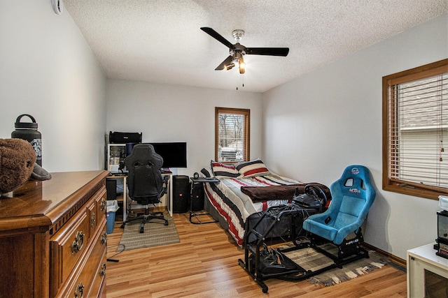 15095 N Barton Lake Dr, Vicksburg, MI 49097 - bedroom with light wood-type flooring, a textured ceiling, and a ceiling fan