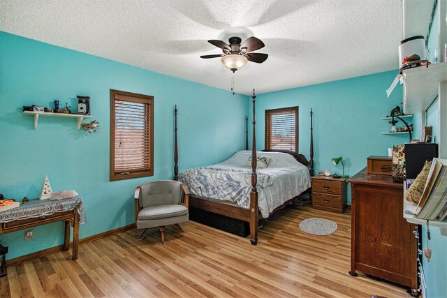 15095 N Barton Lake Dr, Vicksburg, MI 49097 - bedroom featuring baseboards, a ceiling fan, light wood-style floors, and a textured ceiling