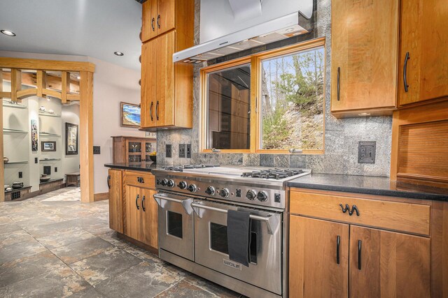 6993 S Lakeshore Dr, Pentwater, MI 49449 - kitchen with exhaust hood, brown cabinetry, tasteful backsplash, dark countertops, and range with two ovens
