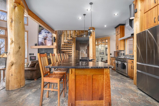 6993 S Lakeshore Dr, Pentwater, MI 49449 - kitchen featuring dark countertops, appliances with stainless steel finishes, a breakfast bar, and stone finish flooring