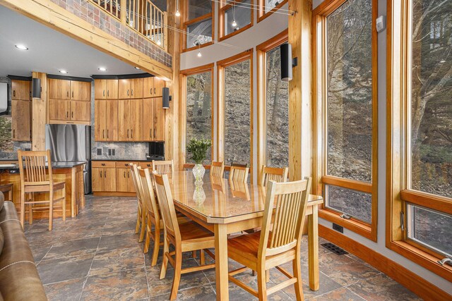6993 S Lakeshore Dr, Pentwater, MI 49449 - dining space with a high ceiling, stone finish floor, baseboards, and recessed lighting