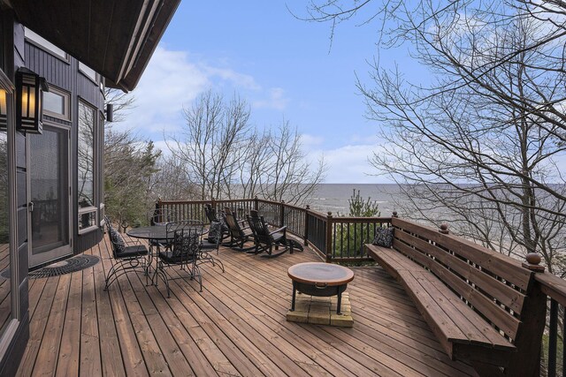6993 S Lakeshore Dr, Pentwater, MI 49449 - wooden deck with outdoor dining area and a water view