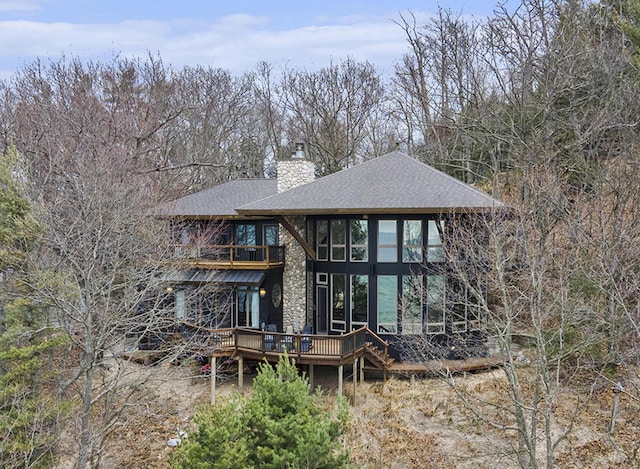 6993 S Lakeshore Dr, Pentwater, MI 49449 - back of house featuring a chimney, a shingled roof, and a wooden deck