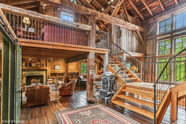 12801 Hills Rd, Buchanan, MI 49107 - staircase with wood-type flooring, beamed ceiling, wooden walls, high vaulted ceiling, and wooden ceiling