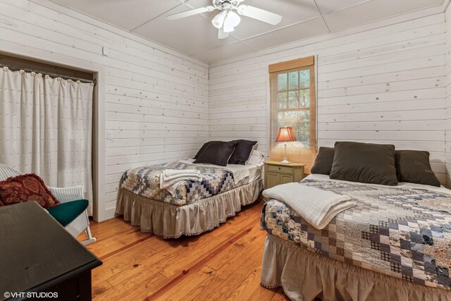 12801 Hills Rd, Buchanan, MI 49107 - bedroom featuring light wood-type flooring, a ceiling fan, and wooden walls