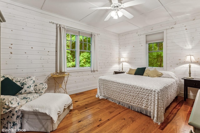 12801 Hills Rd, Buchanan, MI 49107 - bedroom featuring wooden walls, a ceiling fan, and hardwood / wood-style flooring