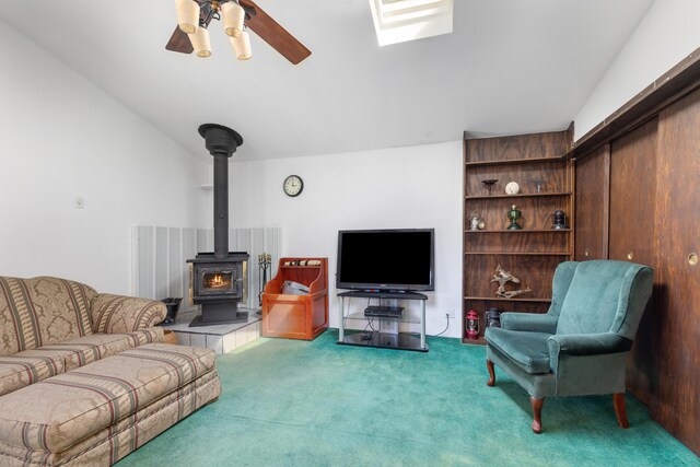 7190 Thornapple River Ct SE, Alto, MI 49302 - living area featuring a wood stove, a ceiling fan, and carpet