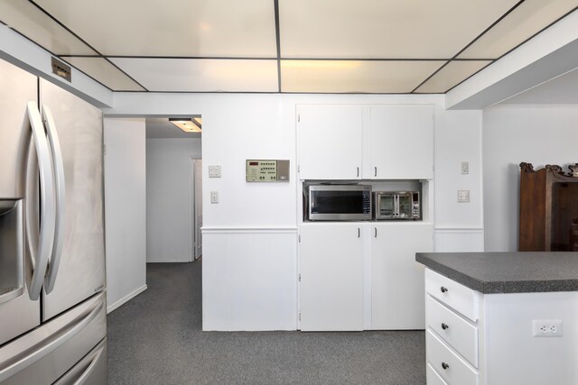 7190 Thornapple River Ct SE, Alto, MI 49302 - kitchen featuring dark carpet, appliances with stainless steel finishes, dark countertops, and white cabinetry