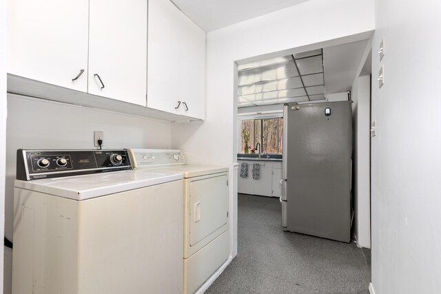 7190 Thornapple River Ct SE, Alto, MI 49302 - laundry room with cabinet space, washing machine and dryer, and a sink