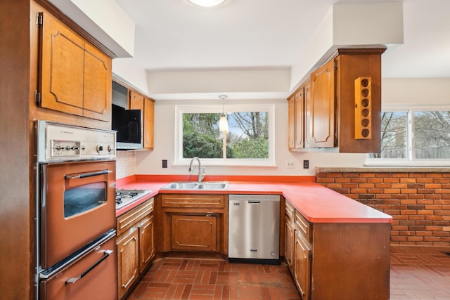 2380 Nixon Rd, Ann Arbor, MI 48105 - kitchen featuring a peninsula, a warming drawer, appliances with stainless steel finishes, a sink, and brick floor