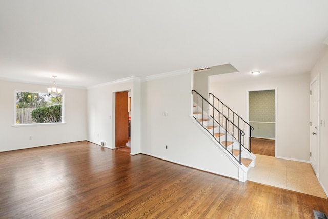 2380 Nixon Rd, Ann Arbor, MI 48105 - interior space with visible vents, an inviting chandelier, ornamental molding, stairway, and wood finished floors