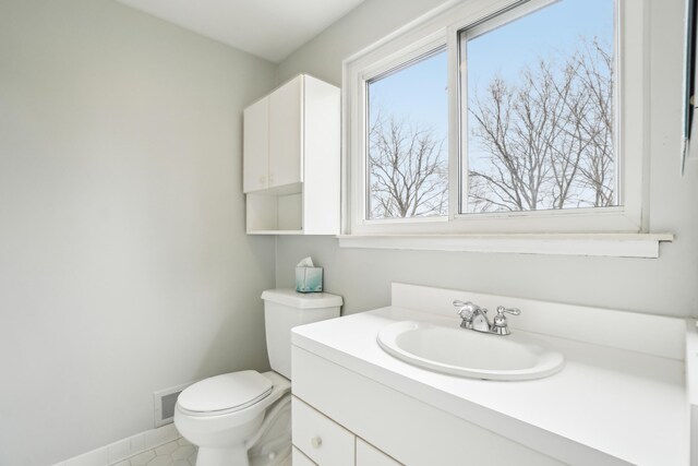 2380 Nixon Rd, Ann Arbor, MI 48105 - bathroom with toilet, vanity, baseboards, and a healthy amount of sunlight