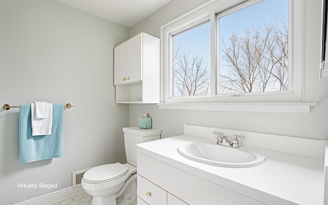 2380 Nixon Rd, Ann Arbor, MI 48105 - bathroom featuring toilet, a healthy amount of sunlight, vanity, and baseboards
