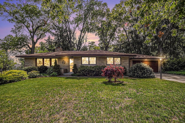 575 Glenwood Ave, Muskegon, MI 49445 - ranch-style home with an attached garage, a lawn, concrete driveway, brick siding, and a chimney
