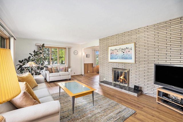 575 Glenwood Ave, Muskegon, MI 49445 - living room featuring wood finished floors, a fireplace, and a wainscoted wall