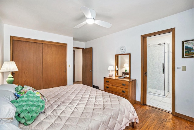 575 Glenwood Ave, Muskegon, MI 49445 - bedroom featuring wood finished floors, a closet, ensuite bath, a ceiling fan, and baseboards