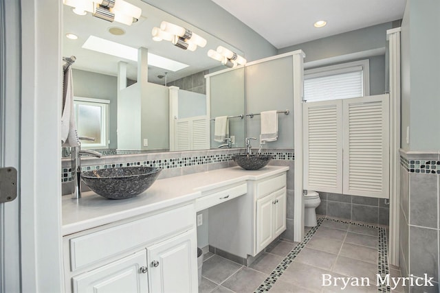 921 Meadow Ridge Dr, Holland, MI 49424 - bathroom with a sink, tile walls, toilet, double vanity, and tile patterned floors