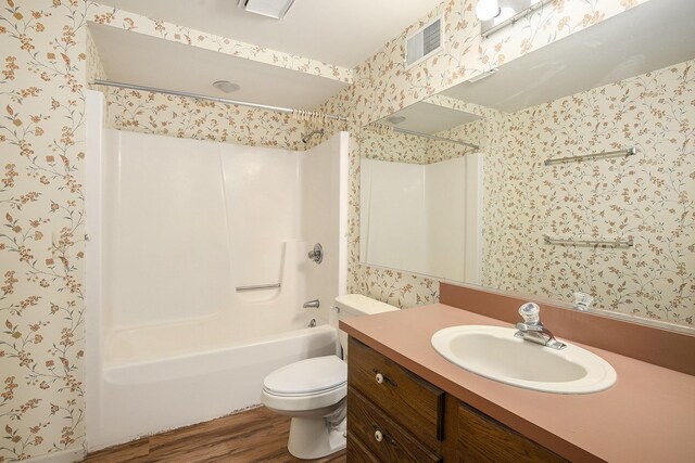 620 Twin Lakes Dr NE, Grand Rapids, MI 49525 - bathroom featuring wallpapered walls, wood finished floors,  shower combination, vanity, and toilet