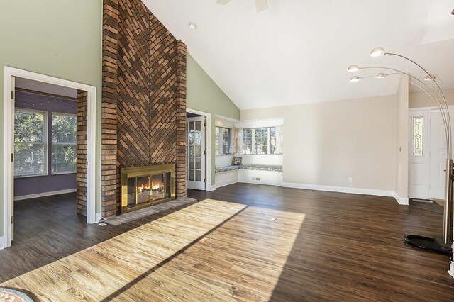 620 Twin Lakes Dr NE, Grand Rapids, MI 49525 - unfurnished living room with high vaulted ceiling, a brick fireplace, baseboards, wood finished floors, and ceiling fan