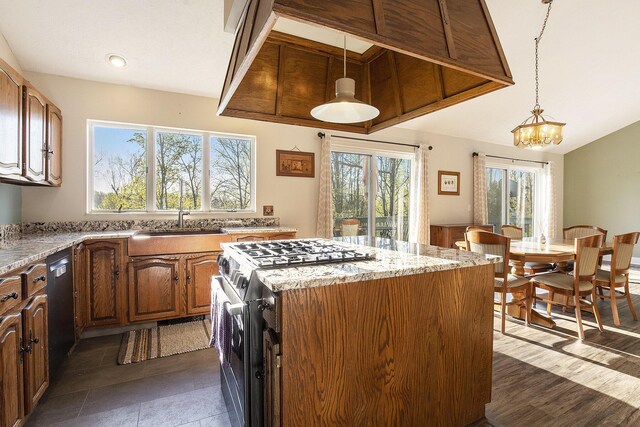 620 Twin Lakes Dr NE, Grand Rapids, MI 49525 - kitchen with stainless steel range with gas stovetop, a sink, a kitchen island, light stone countertops, and pendant lighting