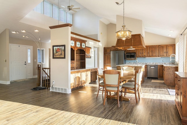 620 Twin Lakes Dr NE, Grand Rapids, MI 49525 - dining space featuring wood finished floors, high vaulted ceiling, a ceiling fan, baseboards, and a chandelier