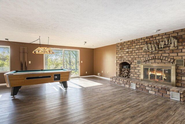 620 Twin Lakes Dr NE, Grand Rapids, MI 49525 - game room featuring a textured ceiling, plenty of natural light, a brick fireplace, and wood finished floors