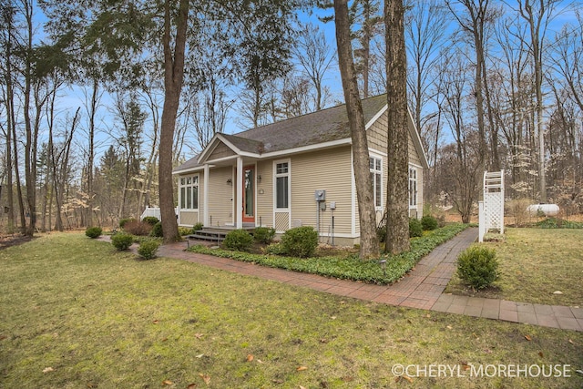 bungalow-style home with roof with shingles and a front yard