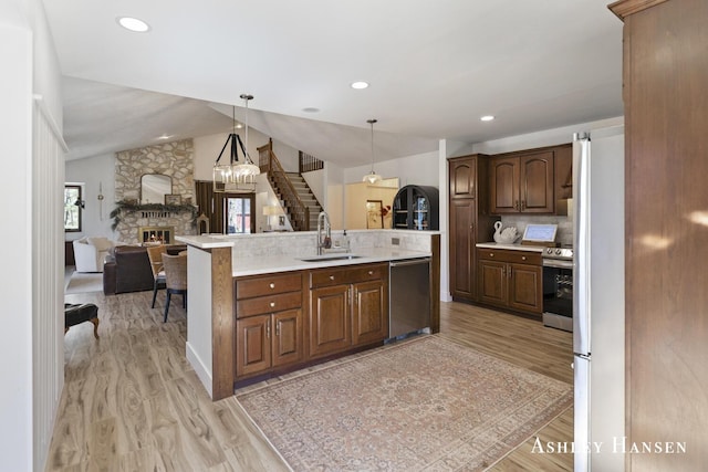 5615 Egypt Valley Ave NE, Belmont, MI 49306 - kitchen featuring a sink, a stone fireplace, open floor plan, light countertops, and light wood finished floors