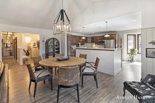 5615 Egypt Valley Ave NE, Belmont, MI 49306 - dining room featuring light wood-type flooring, recessed lighting, vaulted ceiling, a chandelier, and baseboards