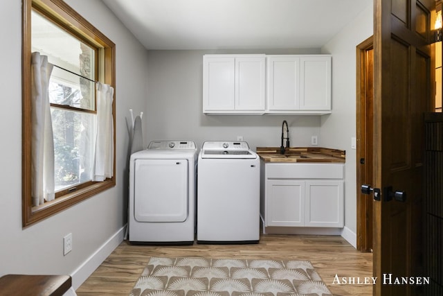 5615 Egypt Valley Ave NE, Belmont, MI 49306 - washroom featuring washer and dryer, cabinet space, light wood-type flooring, and baseboards
