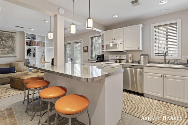 5615 Egypt Valley Ave NE, Belmont, MI 49306 - kitchen with white appliances, dark speckled floor, open floor plan, a sink, and a breakfast bar area